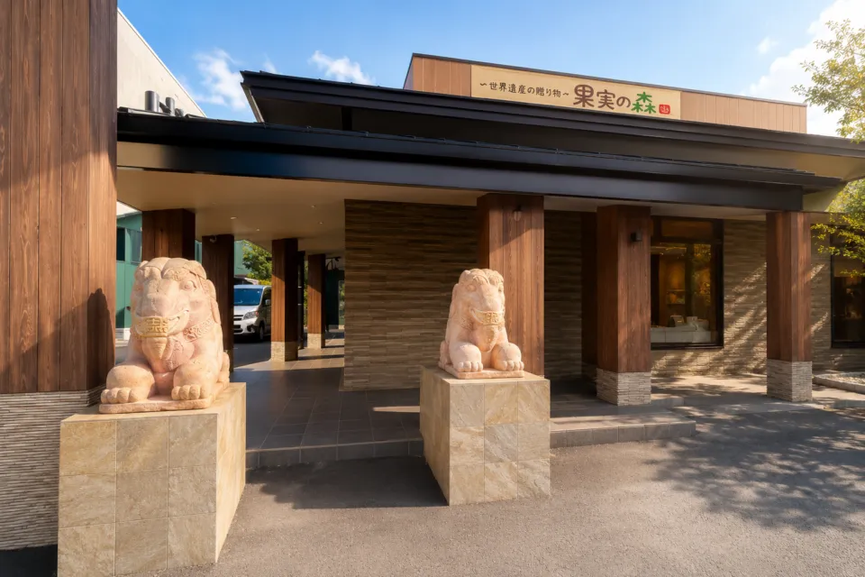 世界遺産の隠れ宿 果実の森の看板と二体の石像がある正面玄関