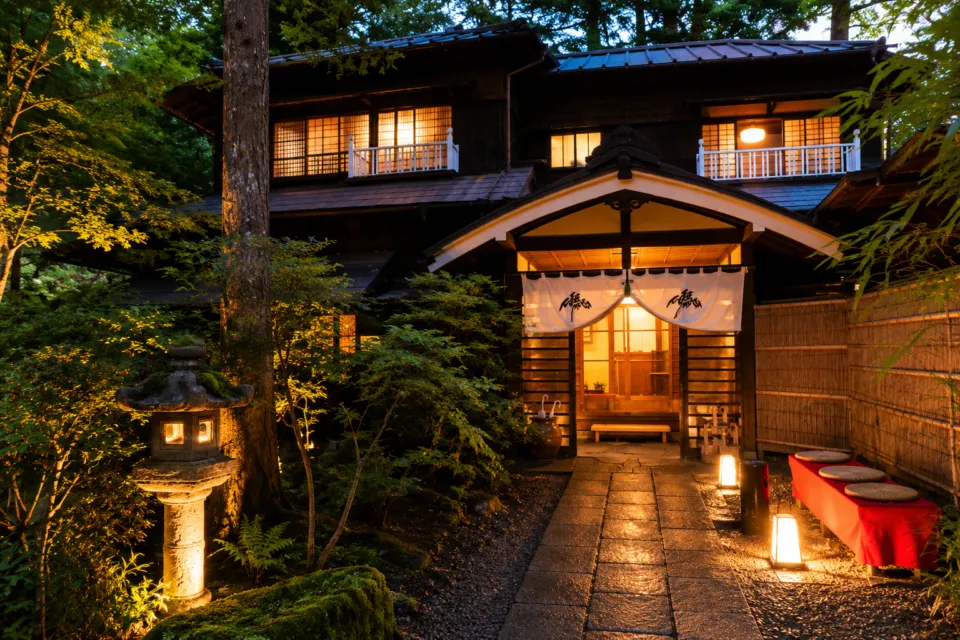 万平ホテルの夜に灯りがともる木造建築