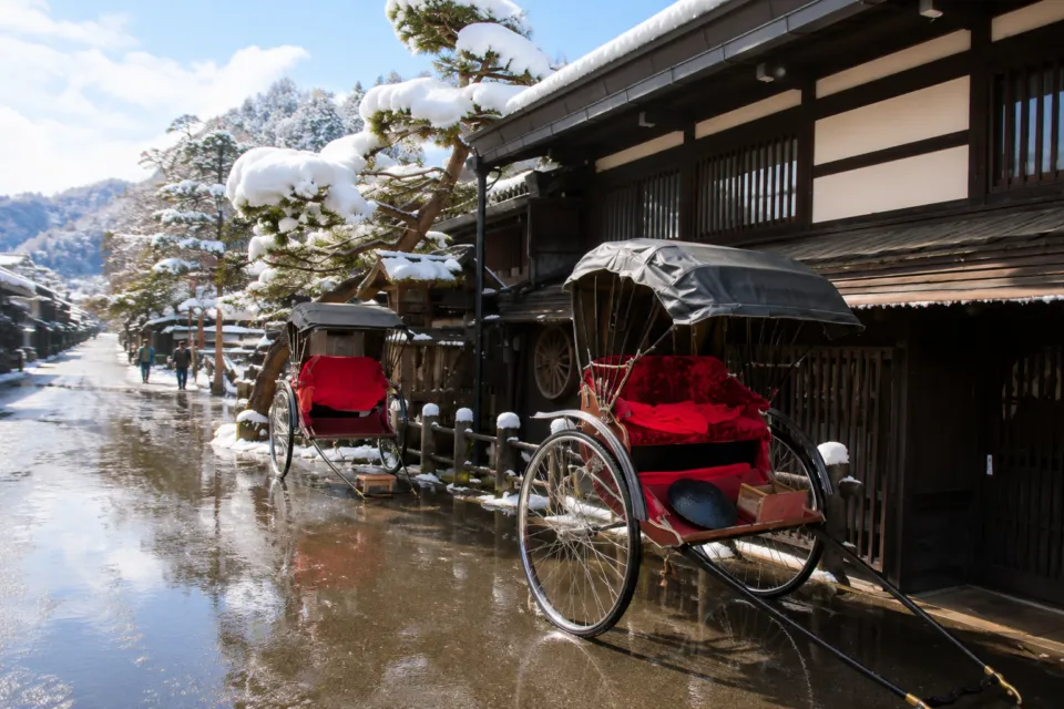 料亭 洲さきの雪が積もる木造外観と人力車
