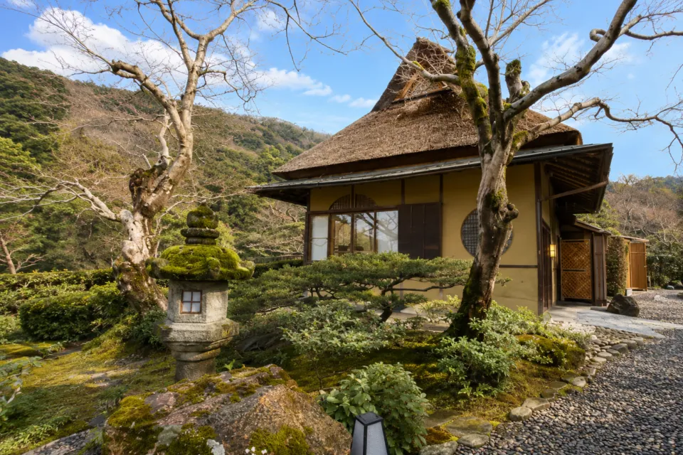 翠嵐 ラグジュアリーコレクションホテル 京都の庭園に建つ茅葺きの建物