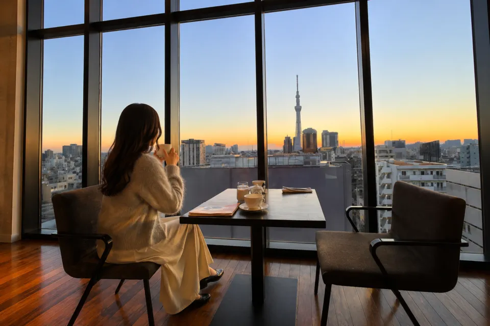 THE GATE HOTEL 雷門 by HULICの東京スカイツリーを望む窓辺で過ごす様子