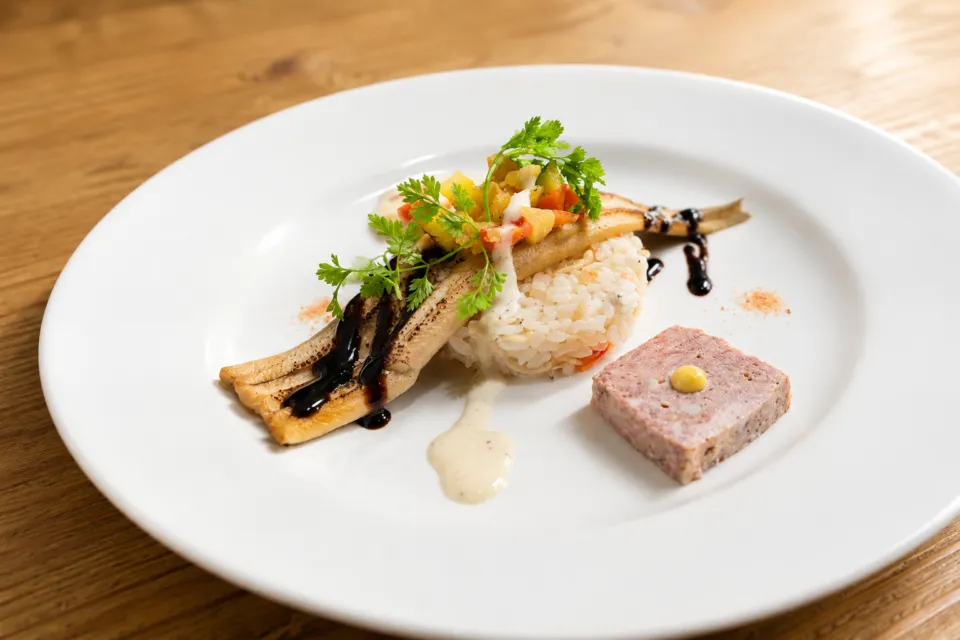 トヨタ白川郷自然學校の魚料理とリゾットを盛り付けた一皿