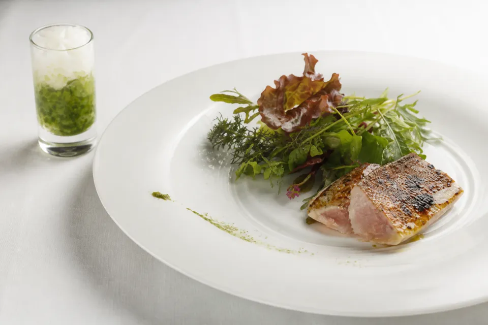 akorduの魚と葉野菜を盛り付けた料理