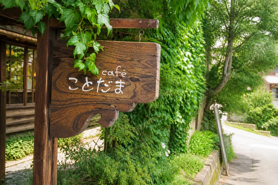 cafe ことだまの緑に囲まれた木製看板