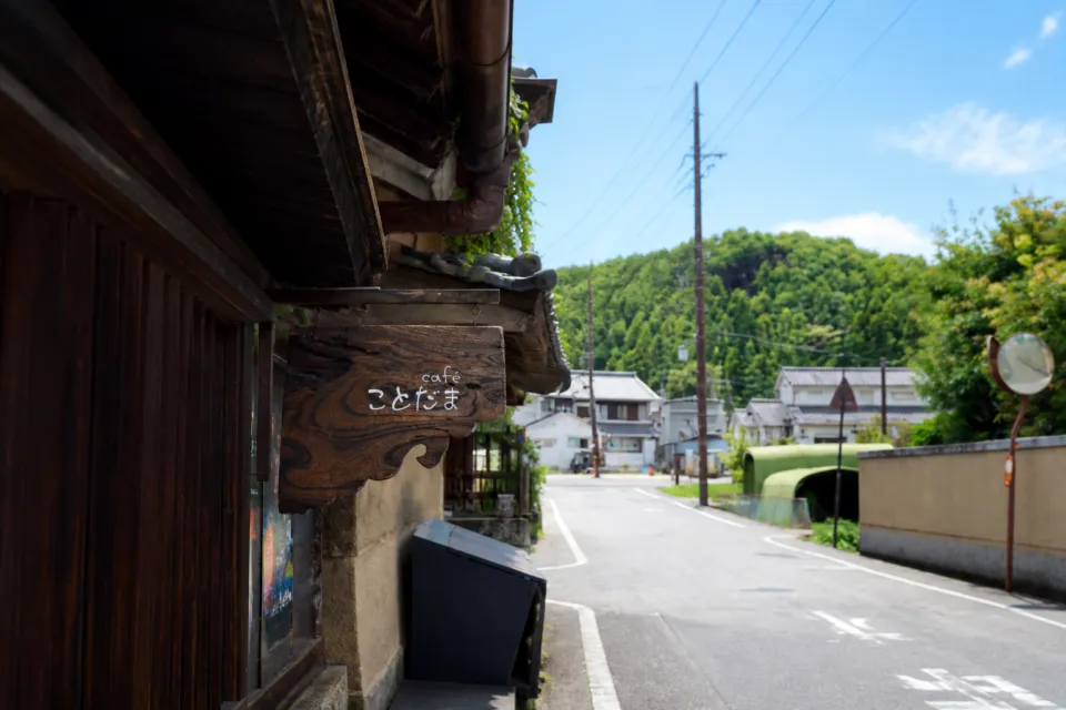 cafe ことだまの木製看板と明日香村の通り