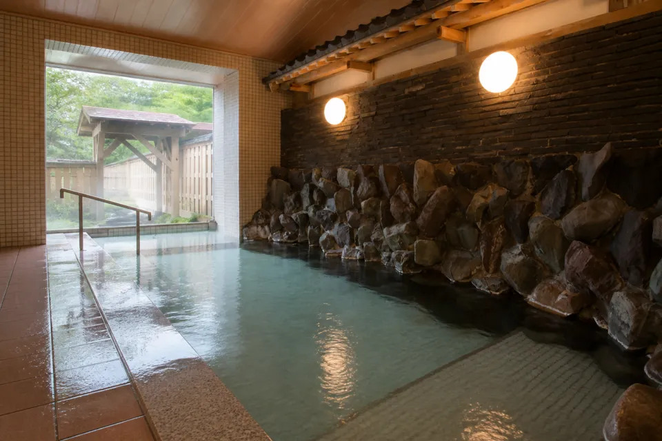 五箇山荘の石壁を配した内風呂