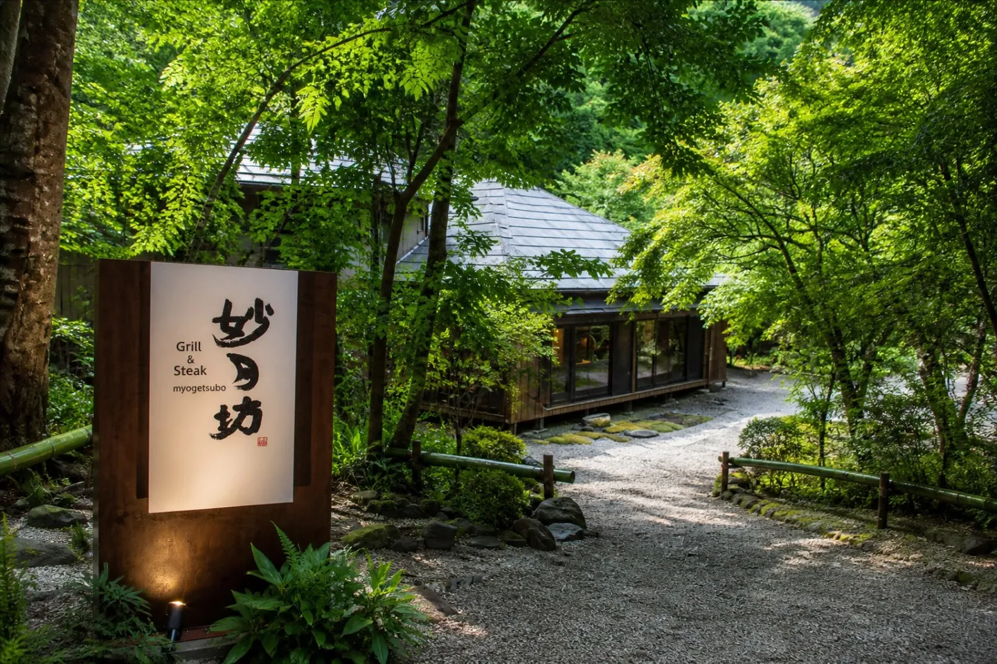 Grill＆Steak 妙月坊の看板と庭に囲まれた建物