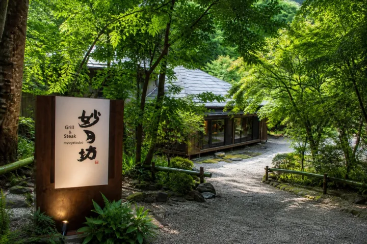 Grill＆Steak 妙月坊の看板と庭に囲まれた建物