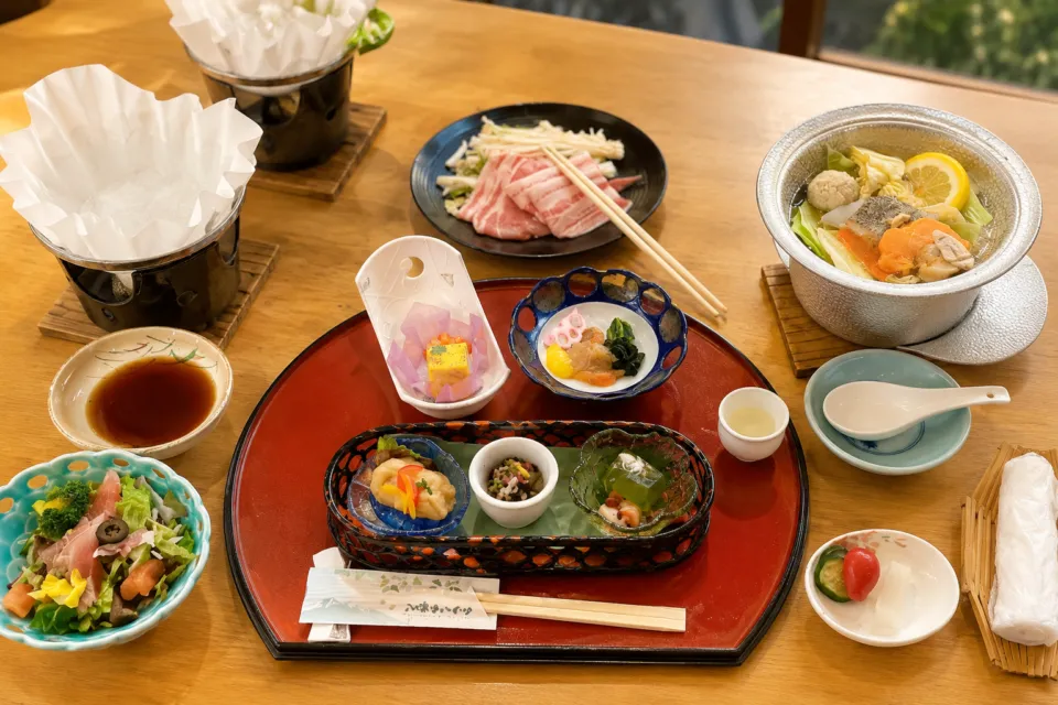 八幡平ハイツの鍋料理と前菜が並ぶ食事