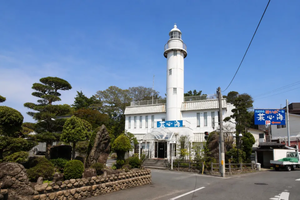萩心海の白い灯台がそびえる店舗外観