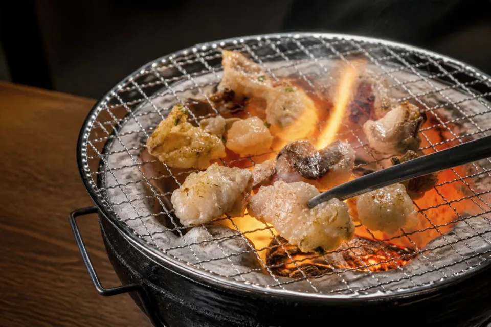 ホルモン屋 壺亭 東口屋台村店の炭火の網で焼くホルモン