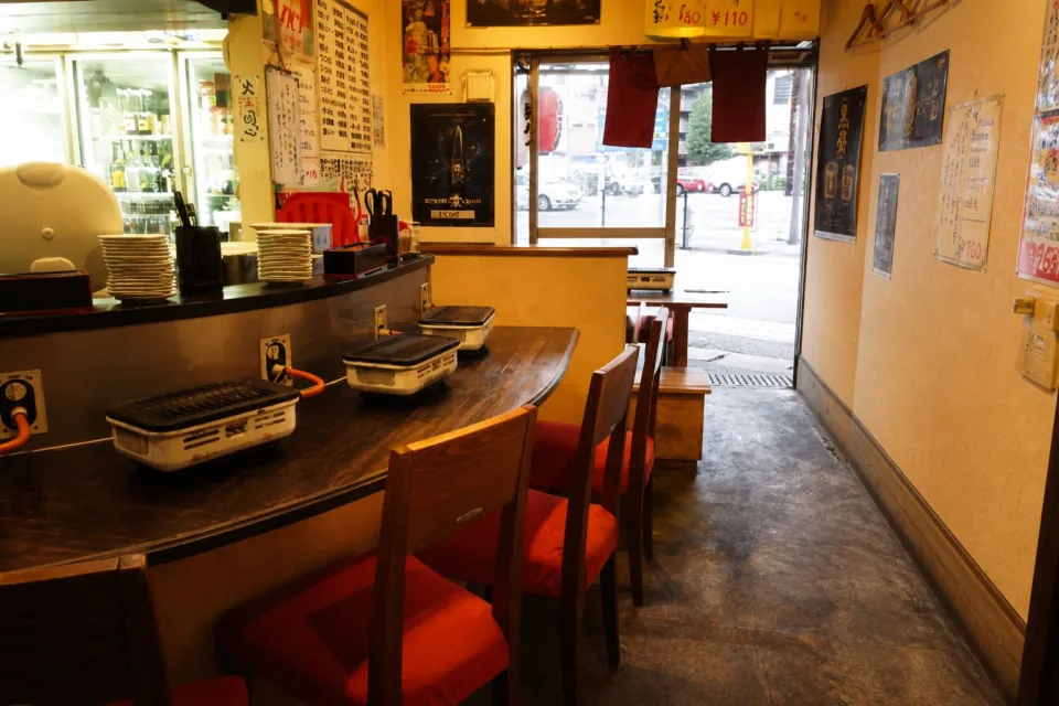 ホルモン屋 壺亭 東口屋台村店の卓上コンロを備えたカウンター席中心の店内