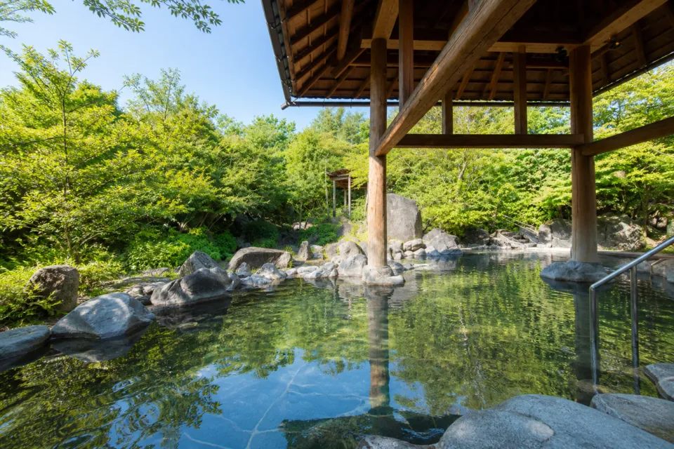 ホテルナガシマの木造屋根と緑に囲まれた奥入瀬渓流の湯