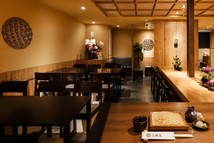 石臼挽蕎麦 三國家の木のテーブルとカウンターが並ぶ石臼挽蕎麦 三國家の店内