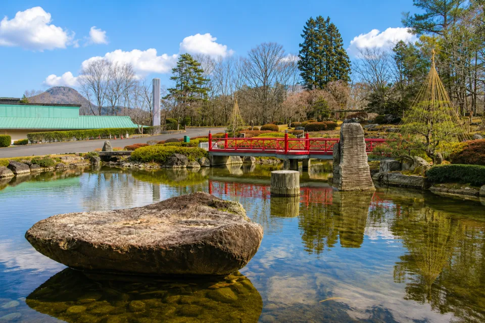 篝火の湯 緑水亭の池と赤い橋がある庭園