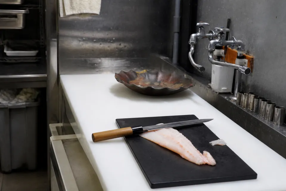 お料理 七草の厨房で魚をさばくために用意された魚と包丁