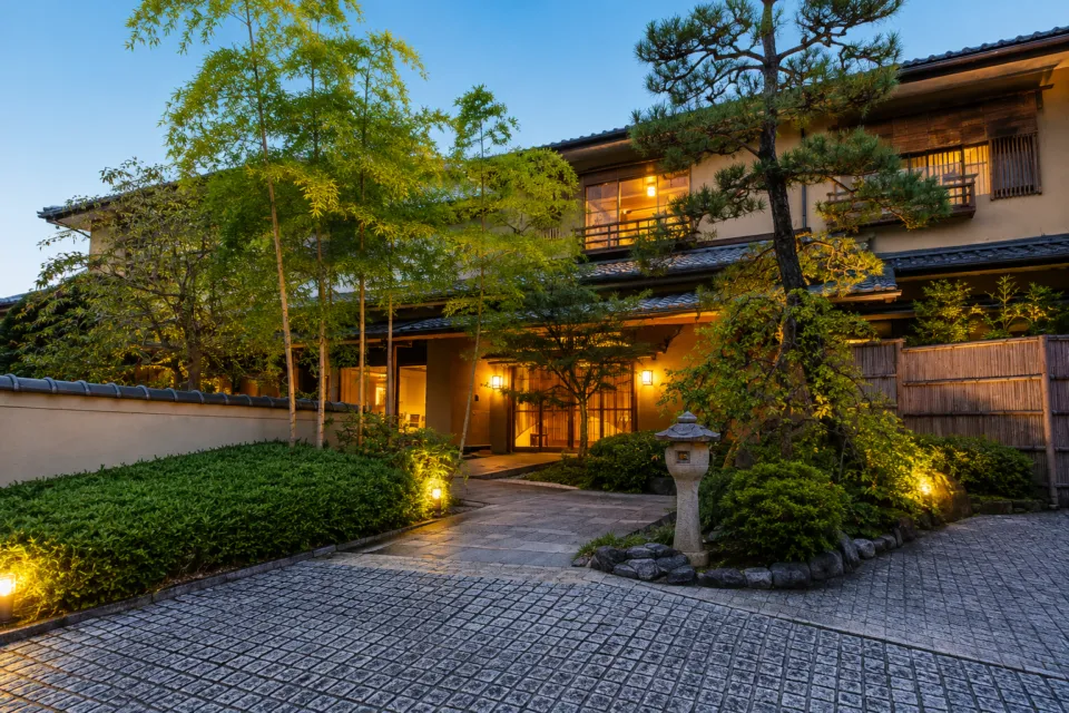 旅亭嵐月の庭園に囲まれた夕暮れの建物外観
