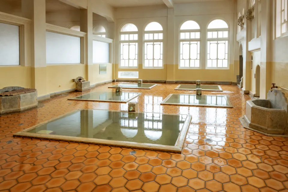 積善館のアーチ窓と五つの浴槽が並ぶ元禄の湯