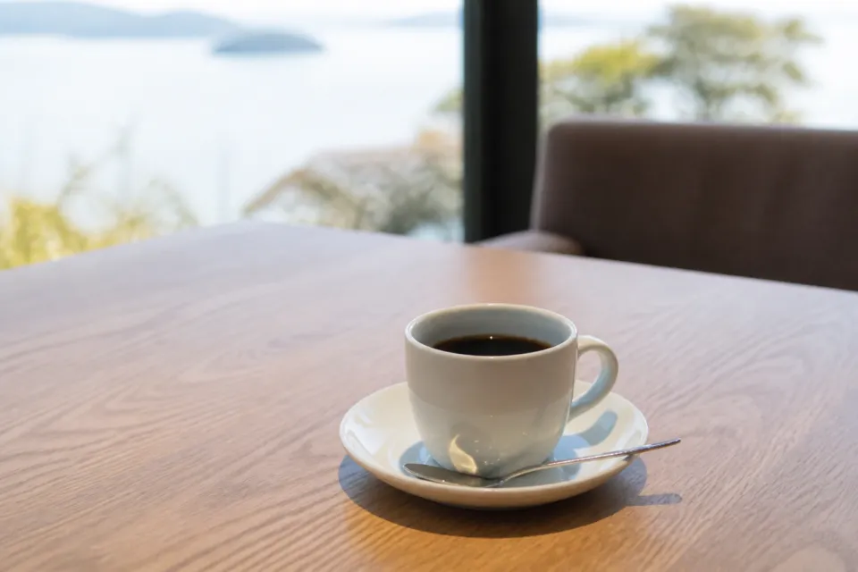シマテラスの木のテーブルに置かれたホットコーヒー
