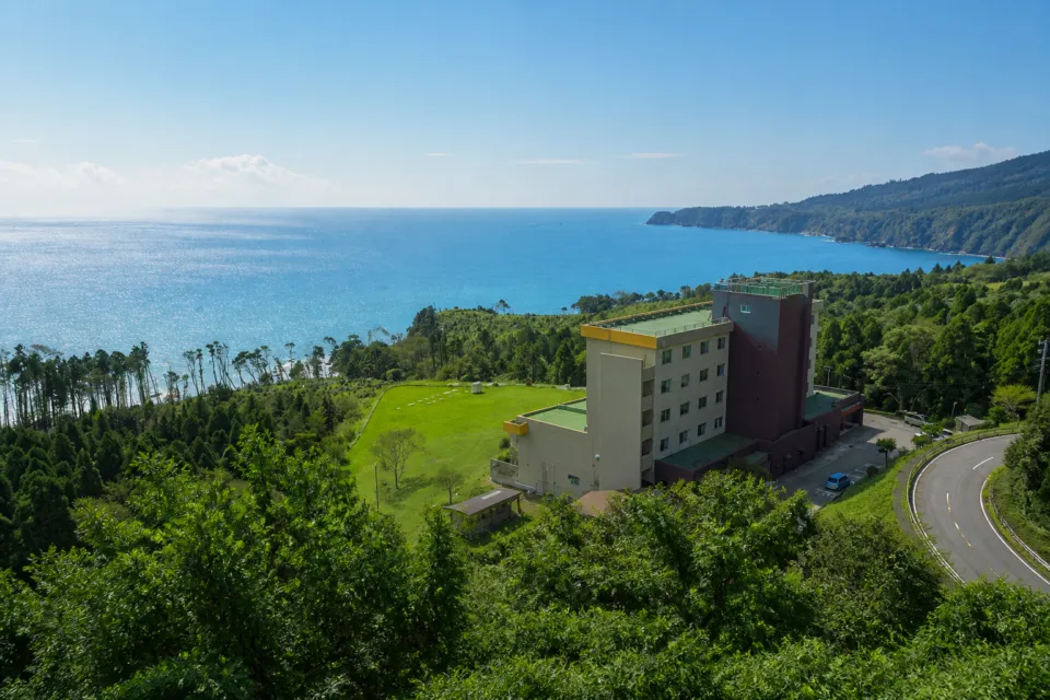 島周の宿さか井の海沿いに立つ建物外観