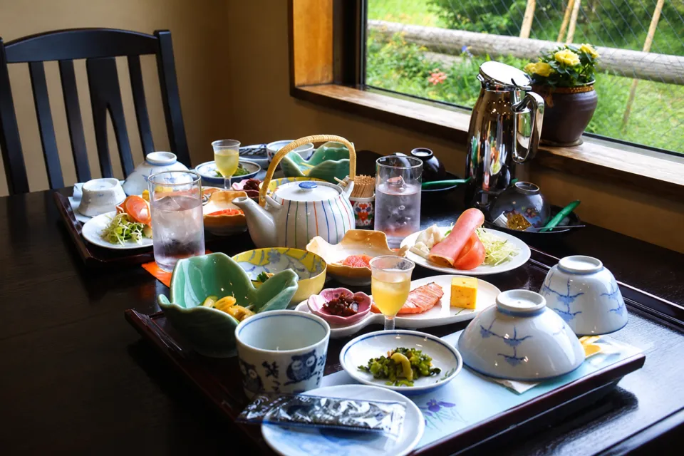 奥州平泉温泉 そば庵 しづか亭の窓辺の席に並ぶ和朝食