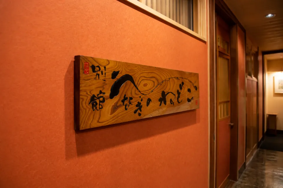 魚登久の別館客室を示す木製看板