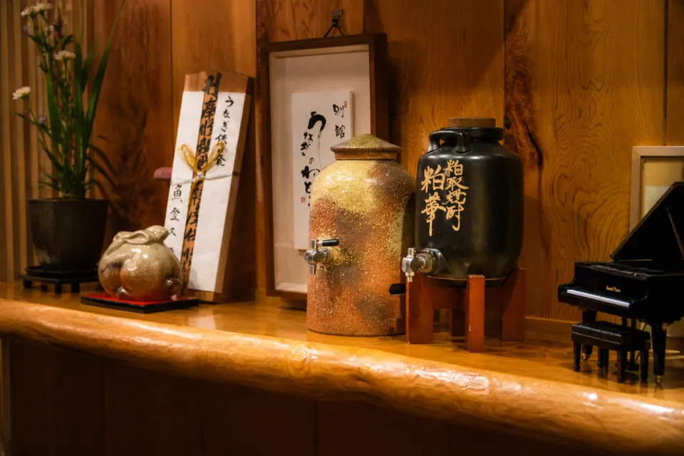 魚登久の器と書を飾った館内棚