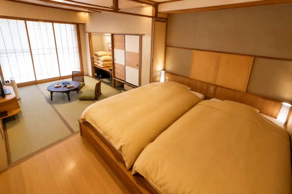 游泉志だてのベッドと畳を備えた和モダン客室