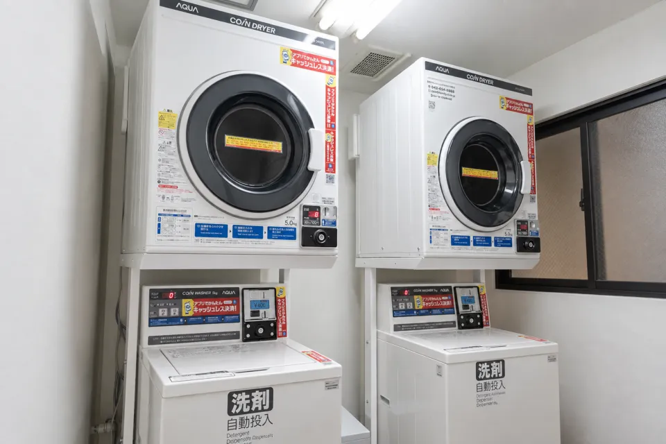 アートホテル佐世保セントラルの洗濯機と乾燥機のあるランドリー