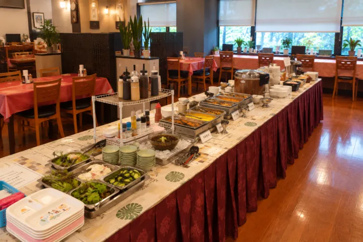 郷土料理レストラン あさばなの料理台とテーブル席が並ぶ店内
