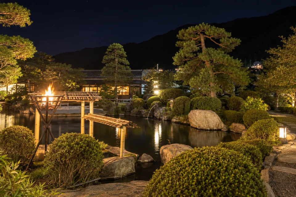 望川館の篝火に照らされた日本庭園