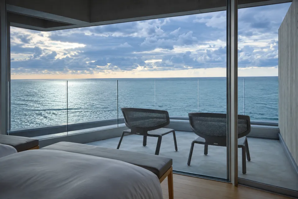 料理旅館 望洋楼の海に浮かぶ寝室のある部屋のベッドと海