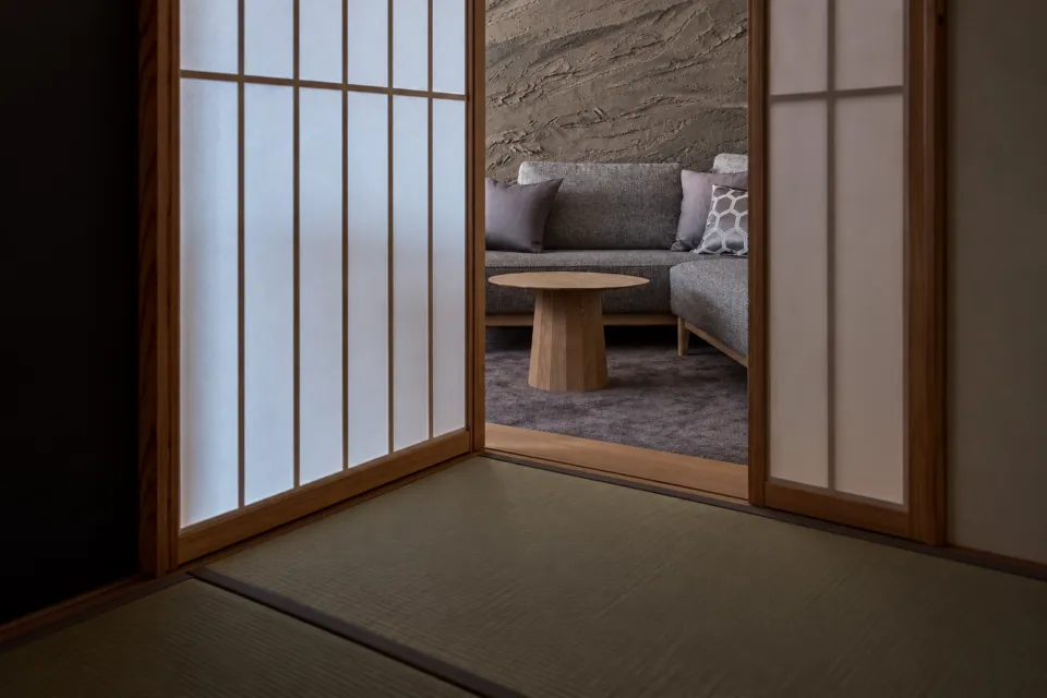 料理旅館 望洋楼の海に浮かぶ寝室のある部屋の畳とソファ