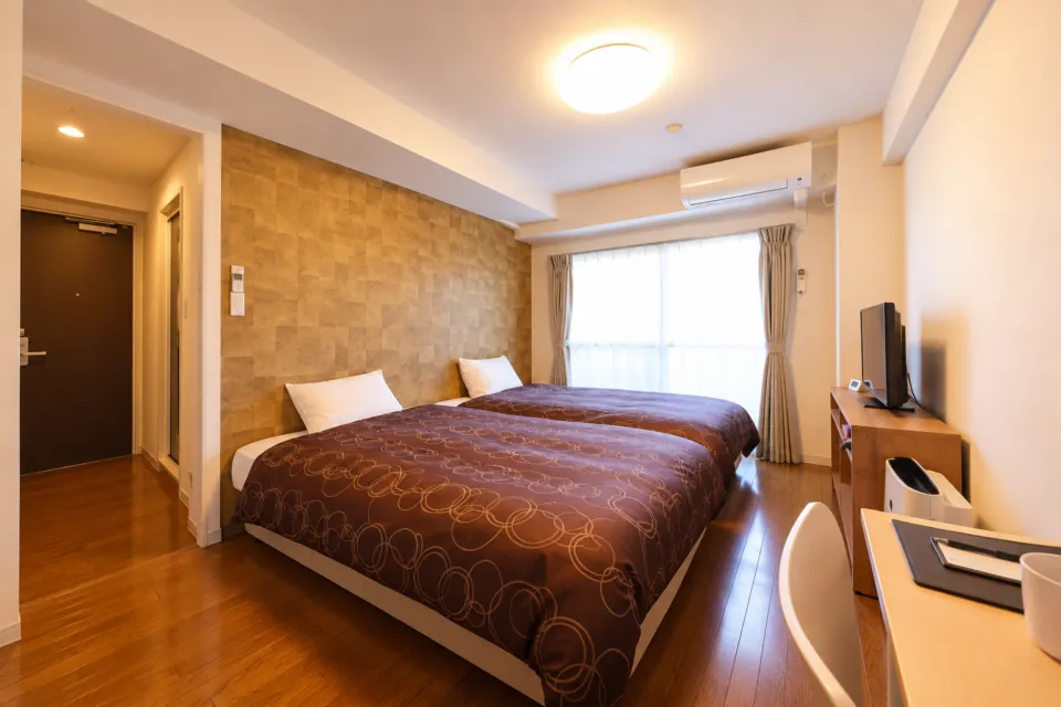 Comfort Stay みやびのベッド2台とデスクのある客室