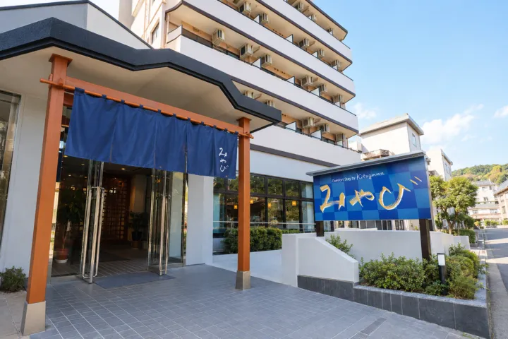 Comfort Stay みやびの正面入口と青い施設看板