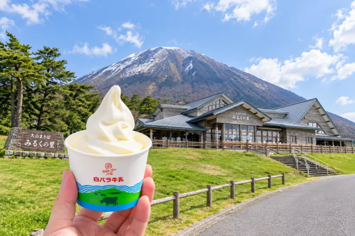 大山まきば みるくの里の建物と大山を背景にした特製ソフトクリーム