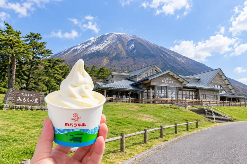 大山まきば みるくの里の建物と大山を背景にした特製ソフトクリーム