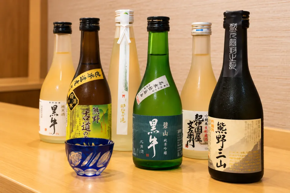 寿司・一品料理 福重のカウンターに並ぶ日本酒の瓶