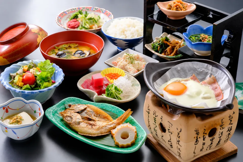 芙蓉別館の焼き魚や小鉢を並べた朝食和膳の一例