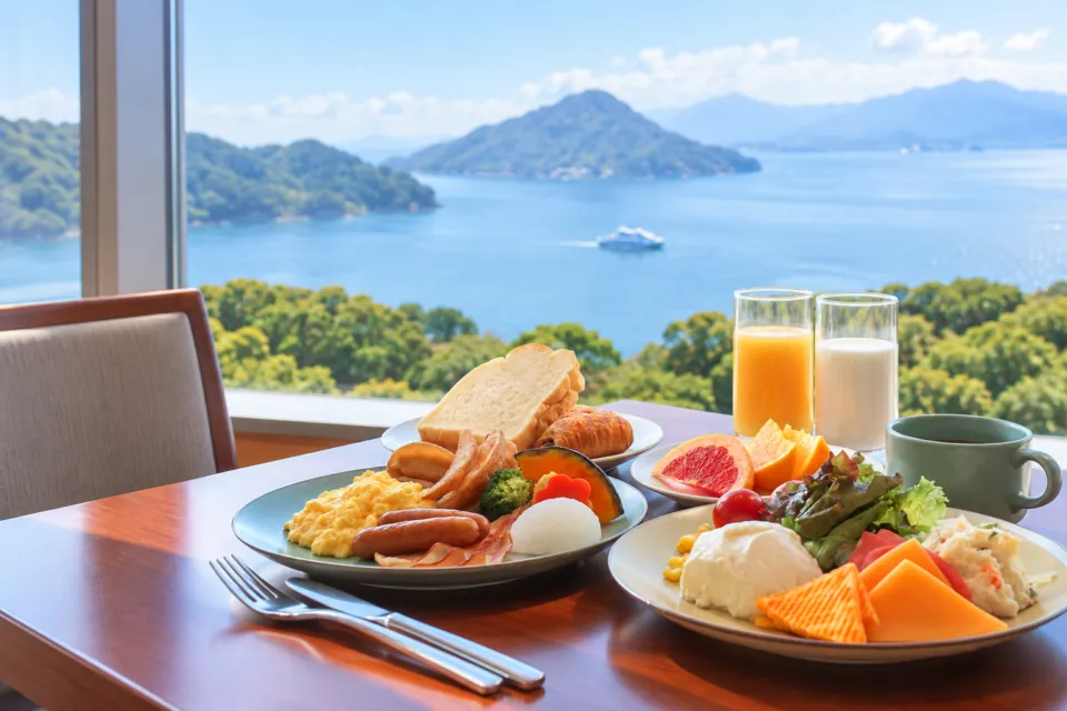 グランドプリンスホテル広島の海を背景に並ぶパンや卵料理の朝食