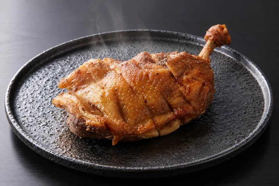 骨付鳥 蘭丸の黒い皿に盛り付けた骨付鳥おや