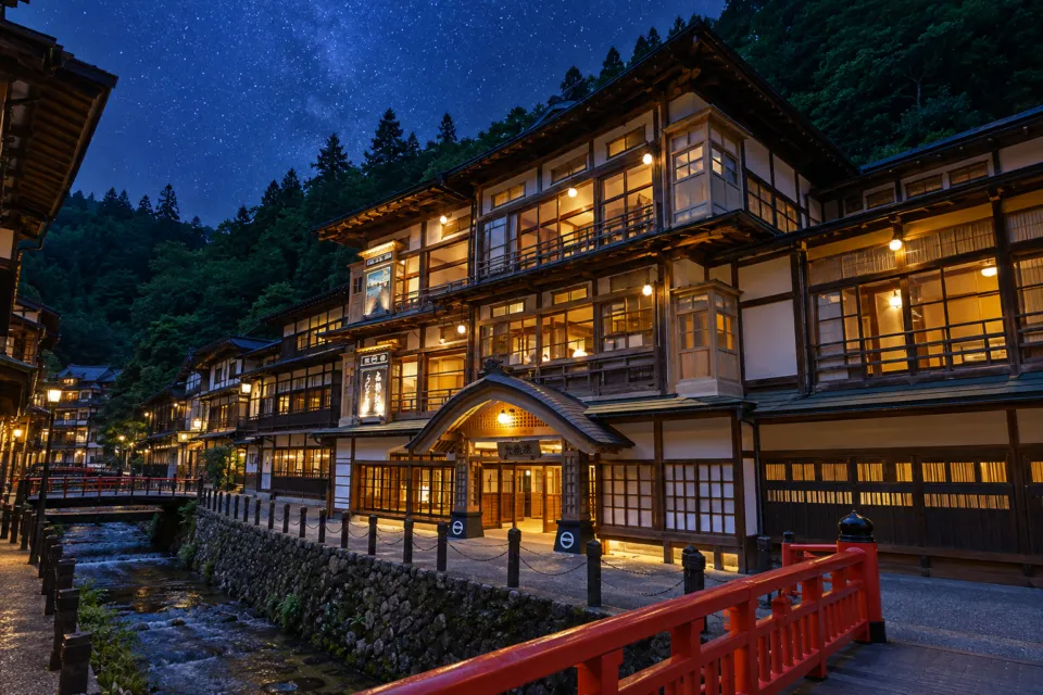 本館古勢起屋の川沿いに建つ木造の本館外観