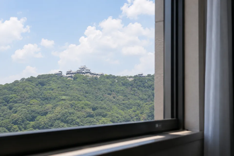 ホテルマイステイズ松山の窓から望む松山城と緑の丘