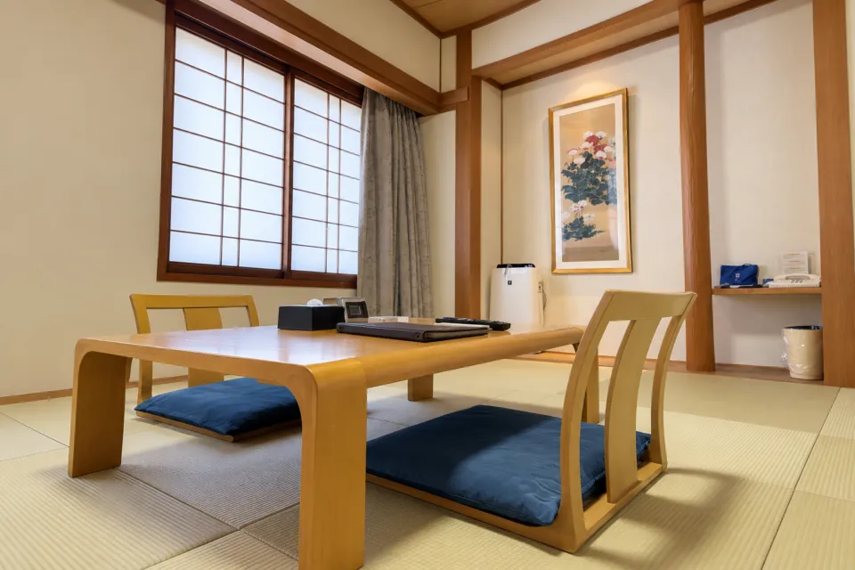 ホテルマイステイズ松山の畳の床と低いテーブルがある和室
