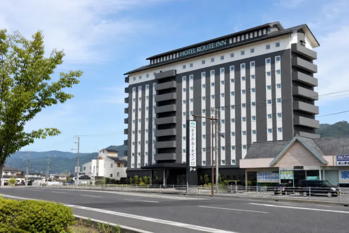 ホテルルートイン津山駅前の夜にライトアップされた外観