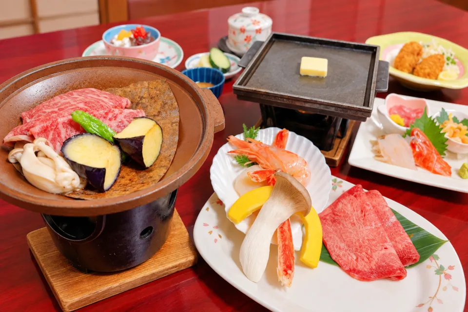 ホテル絶景の館の肉料理と海鮮を並べた夕食