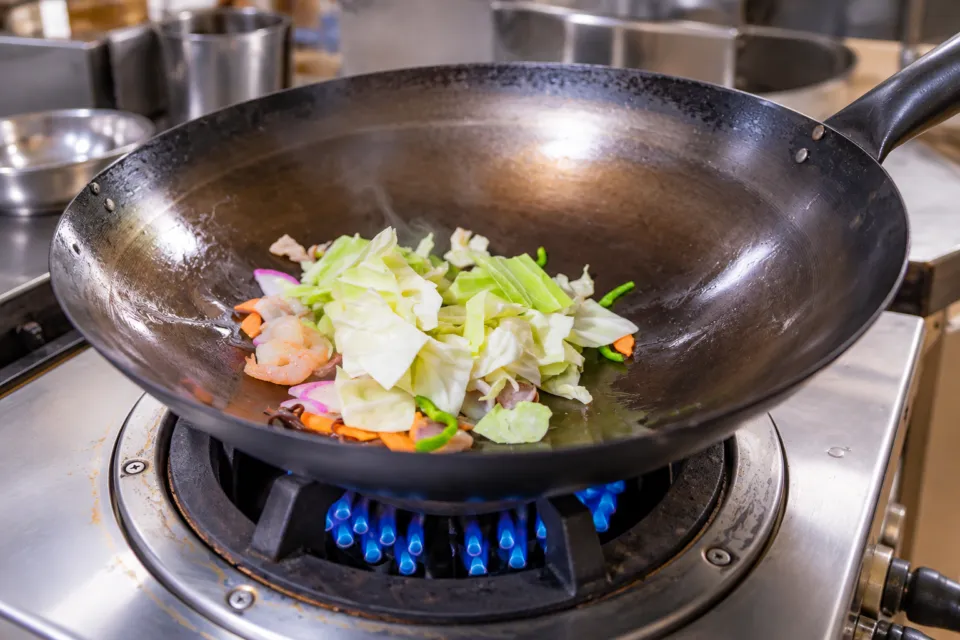 いまきん食堂の中華鍋で野菜を炒める工程