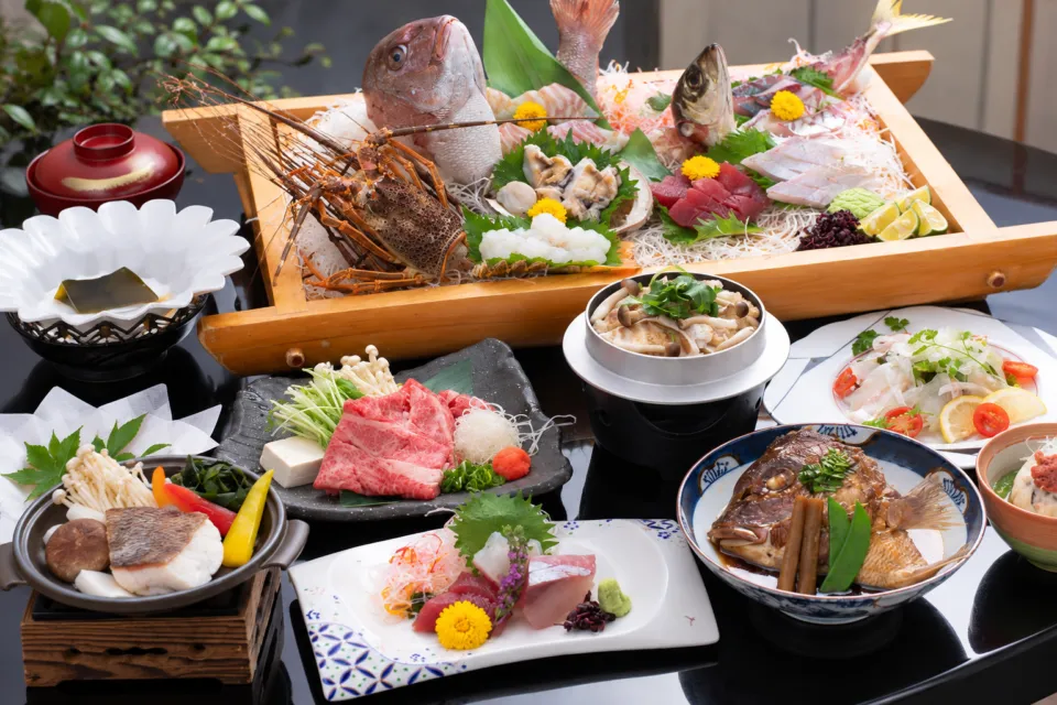 加太海月の舟盛りと肉料理を並べた食事