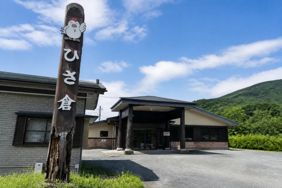 鶏飯の店 ひさ倉の縦長看板と店舗入口を一緒に収めた外観