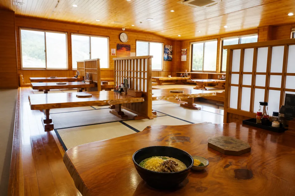 鶏飯の店 ひさ倉の木の一枚板テーブルと畳が並ぶ座敷席
